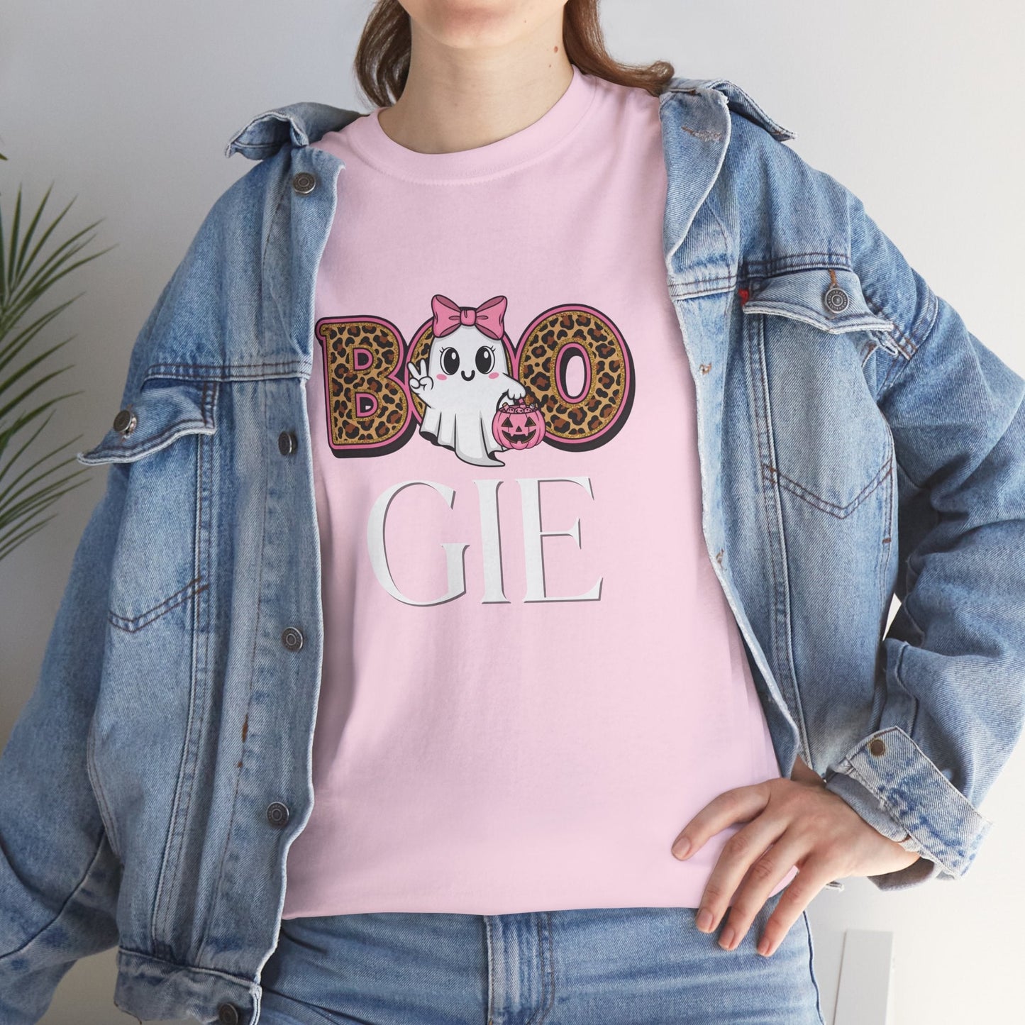Woman wearing pink BOO-GIE Halloween Tee with ghost, leopard print bow, and pumpkin candy bucket design under denim jacket