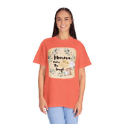 Unisex "Mom's Kitchen" garment-dyed T-shirt in coral, worn by a smiling person, featuring a baking-themed design.