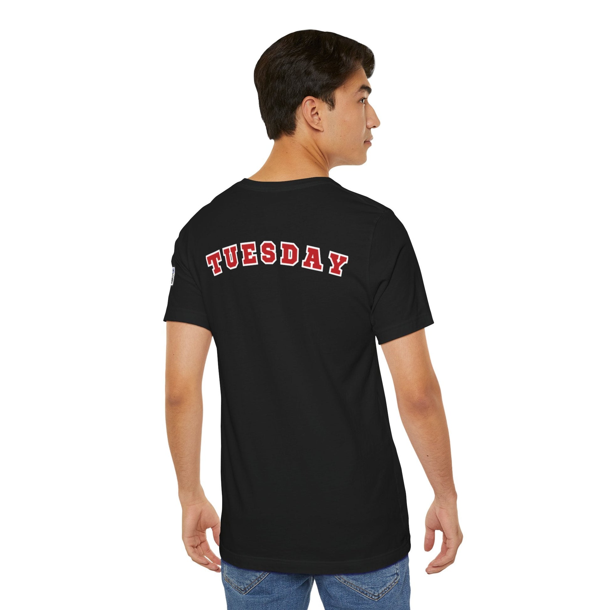 Man wearing black Day of the week Tee with red and white "TUESDAY" text on the back, shown from behind