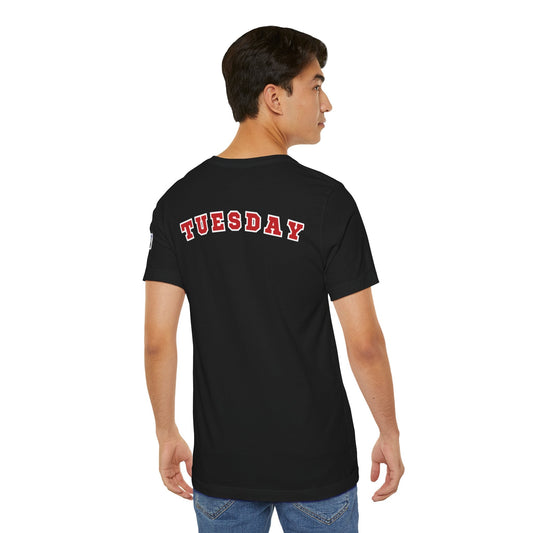 Man wearing black Day of the week Tee with red and white "TUESDAY" text on the back, shown from behind